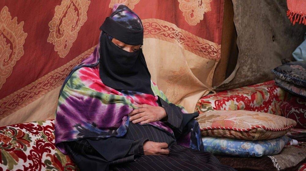 امرأة حامل داخل مأوى مؤقت للنازحين في اليمن، حيث تزيد الظروف المعيشية الصعبة محدودية الحماية من المخاطر الصحية والبيئية خلال الحمل. تصوير: صندوق الأمم المتحدة للسكان.