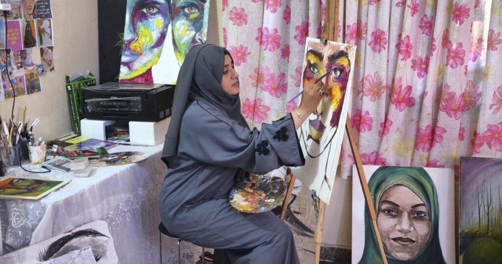 الفنانة اليمنية عبير الحضرمي تعمل على لوحة داخل مرسمها في مدينة المكلا بمحافظة حضرموت. وتعكس تجربتها دور الفنون البصرية في التعبير عن قضايا المرأة والذاكرة الاجتماعية في اليمن. تصوير: سعيد البطاطي / The National، حزيران 2019.